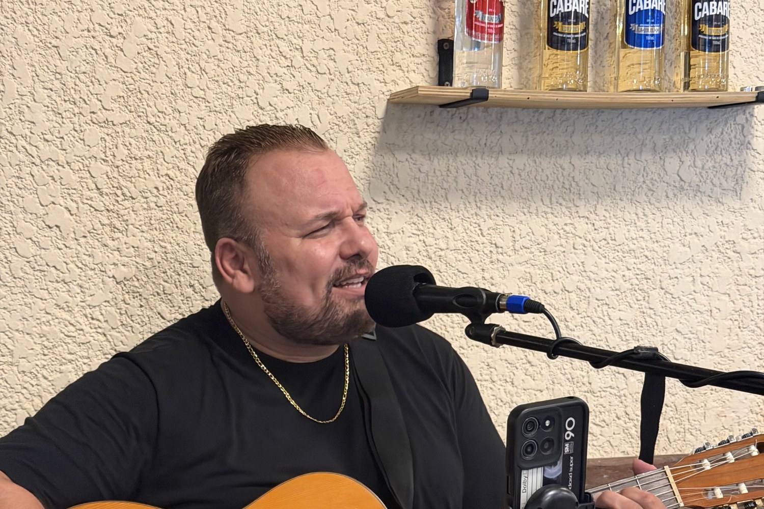 Paulinho Monteiro cantando e tocando violão na música ao vivo do Paulo's